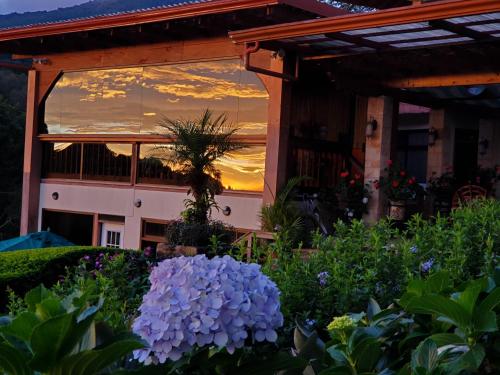 a sunset reflection in a window of a house at Finca Paraiso Mountain Retreat near San Jose Airport in Birrí