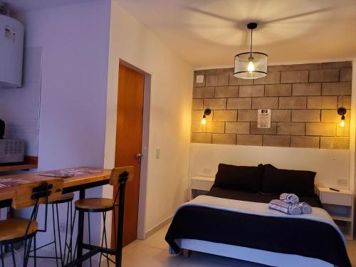 1 dormitorio con cama, mesa y bar en Suite NY, depto a estrenar -15 min Aerop en Monte Grande