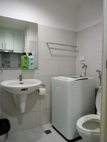 a white bathroom with a sink and a toilet at SEA RESIDENCES F in Manila