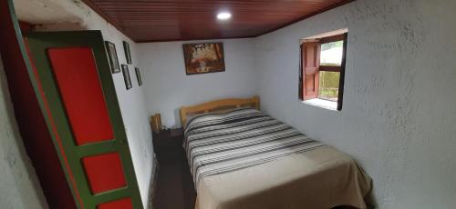 uma pequena cama num quarto com uma janela em D'Antaño em Duitama