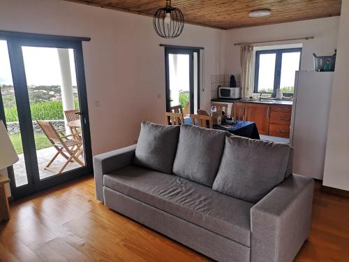 a living room with a couch and a kitchen at Casa do António Júlio in São Roque do Pico