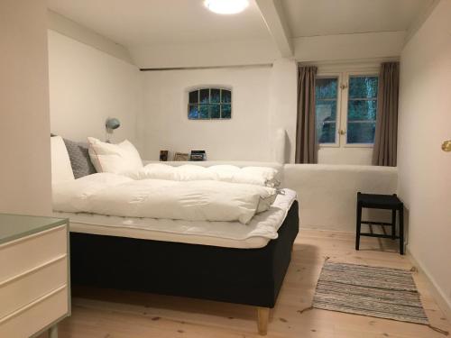 a bedroom with a large bed with white sheets at Tanggården Skoven in Læsø