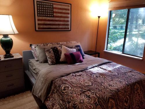 1 dormitorio con 1 cama con bandera americana en la pared en Lovely One bedroom condo with indoor fireplace., en Federal Way
