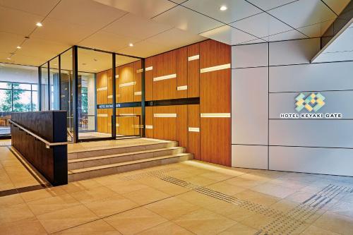 an office lobby with stairs and a sign on the wall at Hotel Keyaki Gate Tokyo Fuchu in Fuchu