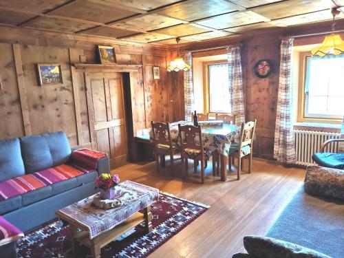 ein Wohnzimmer mit einem Sofa und einem Tisch in der Unterkunft Appartamento Col di Lana Dolomites in Livinallongo del Col di Lana