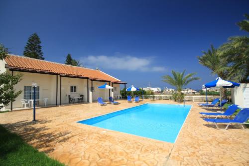 ein Swimmingpool mit blauen Stühlen und Sonnenschirmen in der Unterkunft Helios 2 in Paphos City
