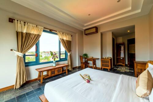 a bedroom with a large white bed and a window at Le Clos Du Fil in Ninh Binh