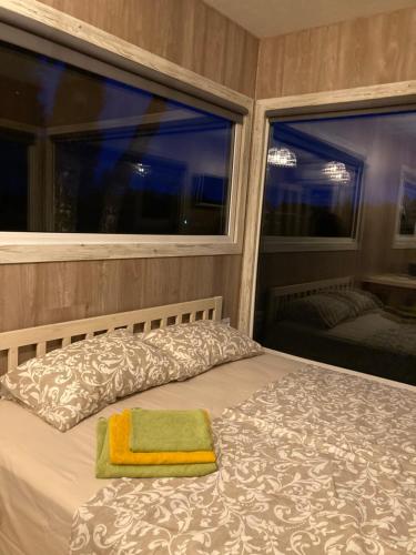 a bedroom with a bed with a window and a green towel at SKY Ranch in Izborsk