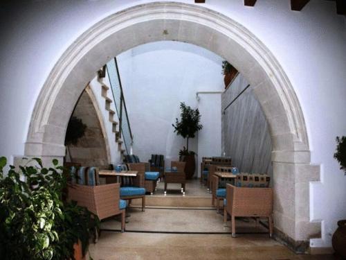 un arco in un edificio con tavoli e sedie di Bellagio Luxury Boutique Hotel a Rethymno