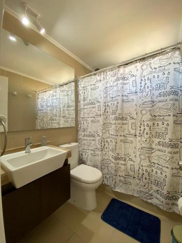 a bathroom with a sink and a toilet and a shower curtain at Departamento Céntrico Full equipado in Copiapó