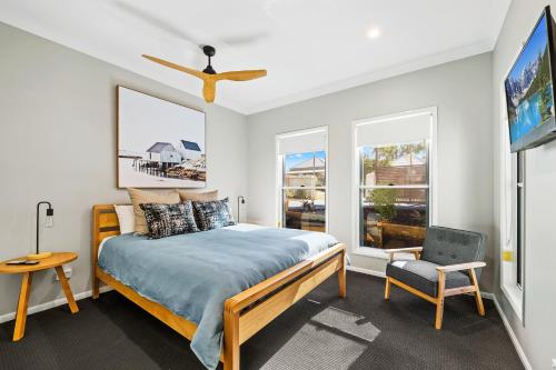 a bedroom with a bed and a tv and a chair at Bluestone Cottages - The Villa in Toowoomba