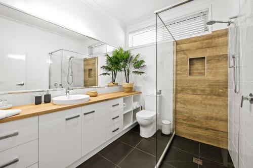 La salle de bains est pourvue de toilettes, d'un lavabo et d'une douche. dans l'établissement Bluestone Cottages - The Villa, à Toowoomba