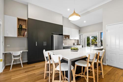 a kitchen with a white table and chairs at Bluestone Cottages - The Villa in Toowoomba