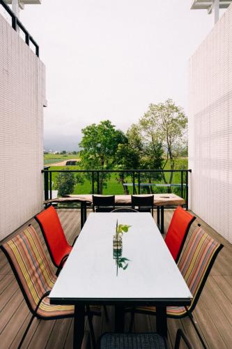 a white table and chairs on a balcony with a view at 禾田遇民宿 Hetianyu in Sanxing