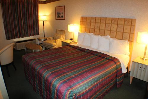 a hotel room with a large bed with a colorful blanket at Days Inn by Wyndham Greeneville in Greeneville