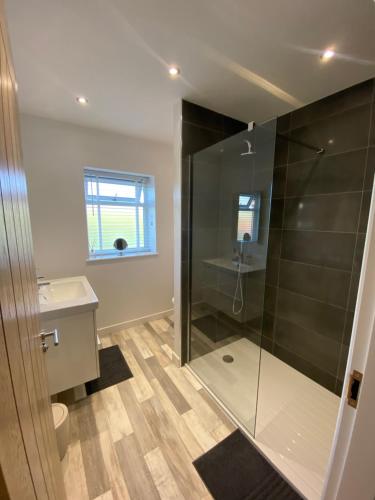 a bathroom with a glass shower and a sink at The Hideout in Anderby