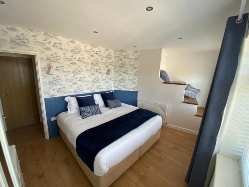 a bedroom with a bed with blue and white sheets at The Hideout in Anderby