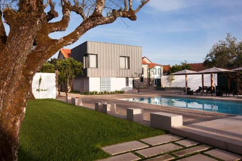 a house with a swimming pool next to a yard at Casas do Lupo in Lapa do Lobo