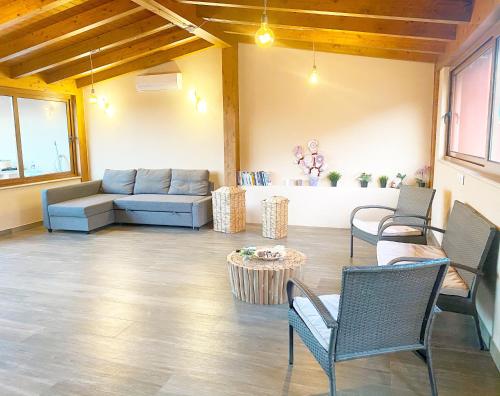 ein Wohnzimmer mit einem Sofa, Stühlen und einem Tisch in der Unterkunft La Casa Di Rosa in Oliveri