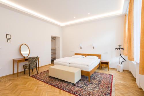 Schlafzimmer mit einem Bett, einem Schreibtisch und einem Spiegel in der Unterkunft Luxusní velký apartmán s terasou v centru Litomyšle in Litomyšl