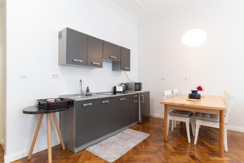 een keuken met grijze kasten en een houten tafel bij Mimi Carera Apartment & Room in Rovinj