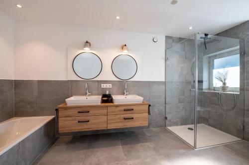 a bathroom with two sinks and a shower at Ferienhaus Megumi in Siegsdorf