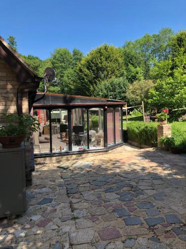 a house with glass doors on a stone patio at South Lodge House in Dormans Land
