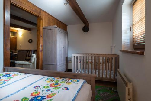 a bedroom with a crib and a room with a dining room at Chalupa Juraj Terchová in Terchová