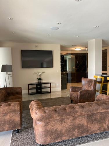 Luxury accomodation in West Vancouver في فانكوفر الغربية: غرفة معيشة مع كنبتين وتلفزيون بشاشة مسطحة