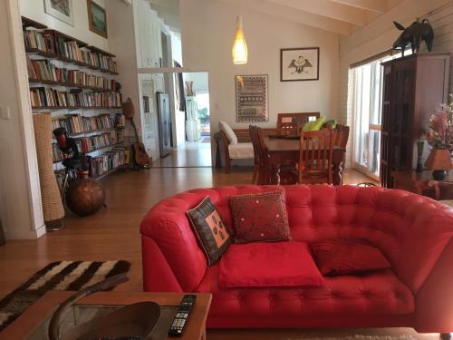 a red couch in a living room with a table at Eumundi Guesthouse and B&B in Eumundi