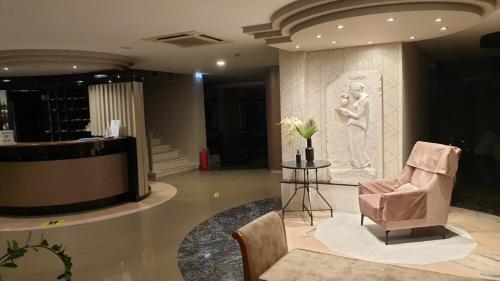 a lobby with a chair and a statue of a woman at Esperia in Thessaloniki