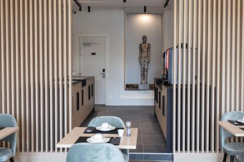 a restaurant with striped walls and blue chairs and tables at Petit-Roannay in Stavelot