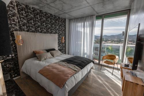 a bedroom with a large bed and a large window at VILLA ALBA ROSULA in Ajaccio