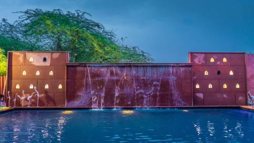 a waterfall on a retaining wall with a fountain at The Mandore - a leafy resort in Jodhpur