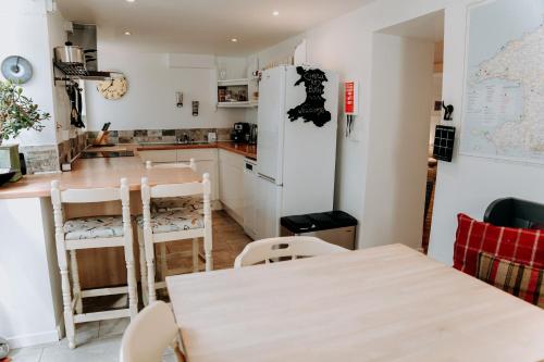 a kitchen with a table and a refrigerator at Hamilton Lodge - Cottage sleeps 8 in Fishguard