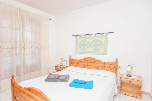 a bedroom with a white bed with a blue towel on it at Appartamento Piano terra in Sarroch