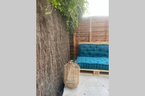 un divano blu seduto accanto a un muro di Apt 35 m2 Baignoire Balnéo terrasse privée a Amfreville-la-Mi-Voie