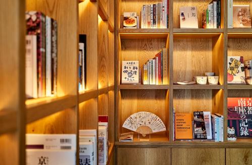 a book shelf with many books on it at Tassel Hotel Sanjo Shirakawa in Kyoto