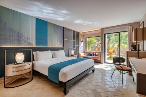 Holiday Inn Resort Phuket, an IHG Hotel في شاطيء باتونغ: غرفه فندقيه بسرير ومطبخ