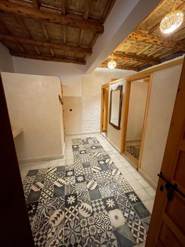 a room with a patterned floor in a house at Issouganes N Toubkal Maison d hôtes in Oussertek
