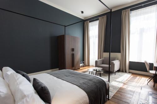 a bedroom with a large bed and a chair at Petit-Roannay in Stavelot
