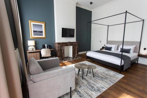 a bedroom with a bed and a living room with a couch at Petit-Roannay in Stavelot