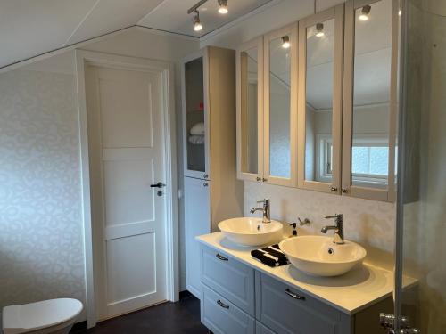 a bathroom with two sinks and a mirror at Lyxig Villalägenhet i centrala Uddevalla - Spabad in Uddevalla
