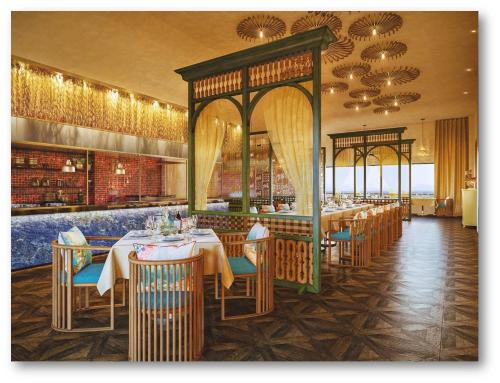 a dining room with tables and chairs in a restaurant at Radisson Blu Resort Visakhapatnam in Visakhapatnam