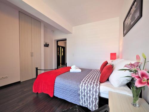 a bedroom with a bed with red and white pillows at VIP Apartamenty Stara Polana in Zakopane