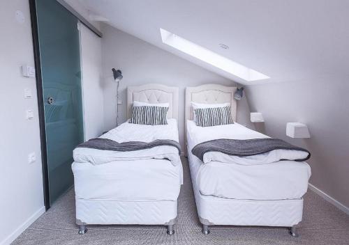 two beds in a room with a white wall at Hotel Hötorget in Stockholm