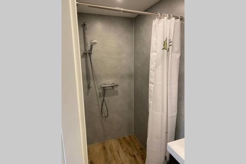 a shower with a white shower curtain in a bathroom at Smart Home - Die etwas andere Ferienwohnung! in Brandenburg an der Havel