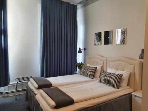 a bedroom with a large bed with two pillows at Hotel Hötorget in Stockholm