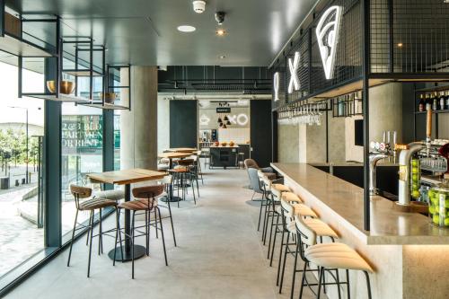a bar with stools and tables in a restaurant at ibis London Sutton Point in Sutton