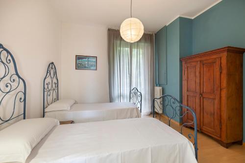 a bedroom with two beds and a dresser in it at Diana - By Impero House in Stresa